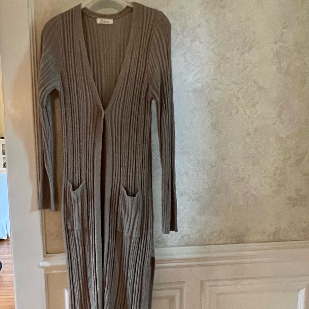 Long acrylic sweater with split hem and button closure. Never worn. 46”